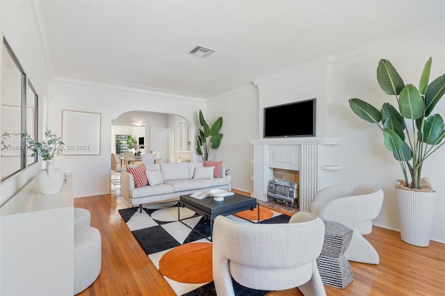 living room with light hardwood / wood-style floors and crown molding