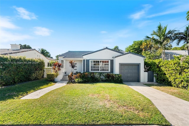 single story home featuring a garage and a front lawn