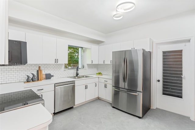 kitchen with white cabinets, sink, stainless steel appliances, and tasteful backsplash