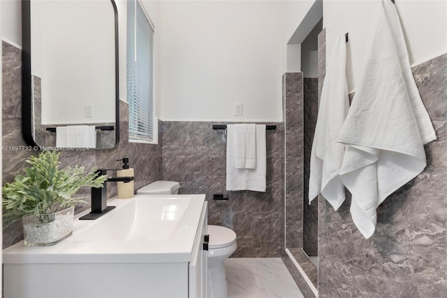 bathroom with vanity, tile walls, and toilet