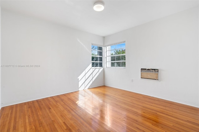 empty room featuring wood-type flooring and an AC wall unit