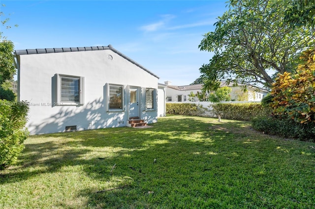 back of house with a lawn