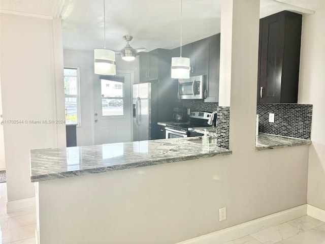 kitchen featuring backsplash, light stone countertops, appliances with stainless steel finishes, decorative light fixtures, and kitchen peninsula