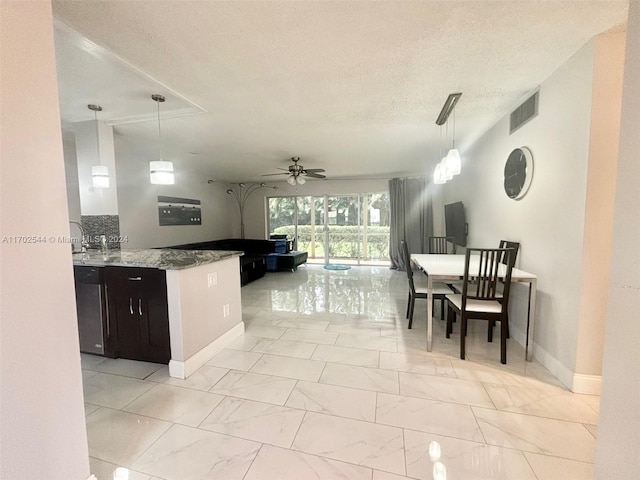 kitchen with decorative backsplash, a textured ceiling, ceiling fan, pendant lighting, and stone counters