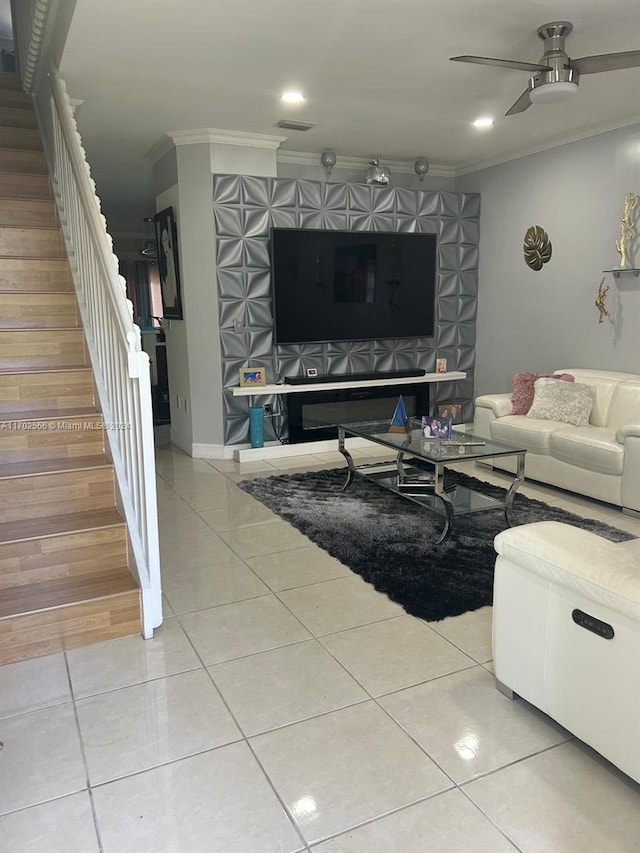 living room with light tile patterned floors, ceiling fan, and crown molding