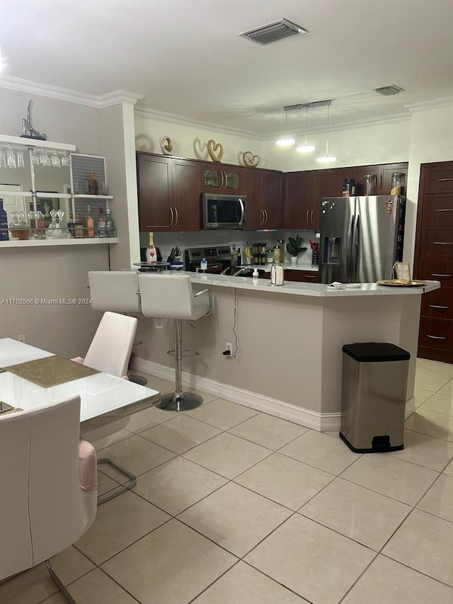 kitchen featuring a kitchen breakfast bar, stainless steel appliances, light tile patterned floors, and ornamental molding