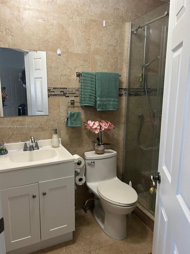 bathroom featuring walk in shower, vanity, tile walls, tile patterned flooring, and toilet