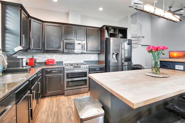 kitchen featuring backsplash, sink, appliances with stainless steel finishes, and light hardwood / wood-style flooring