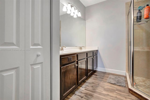 bathroom featuring vanity, hardwood / wood-style flooring, and a shower with door