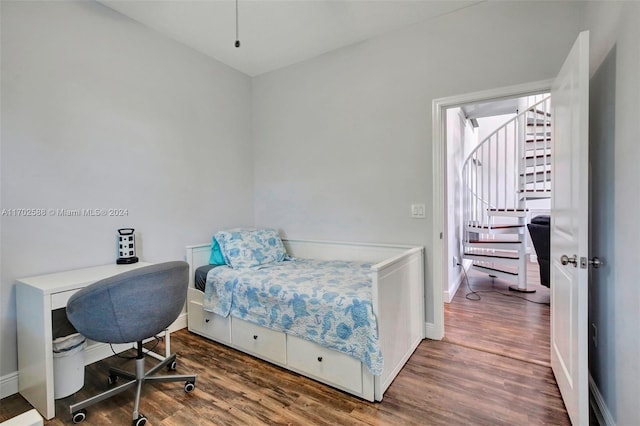 bedroom with dark hardwood / wood-style flooring and multiple windows