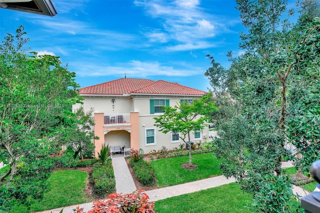 mediterranean / spanish home featuring a front lawn