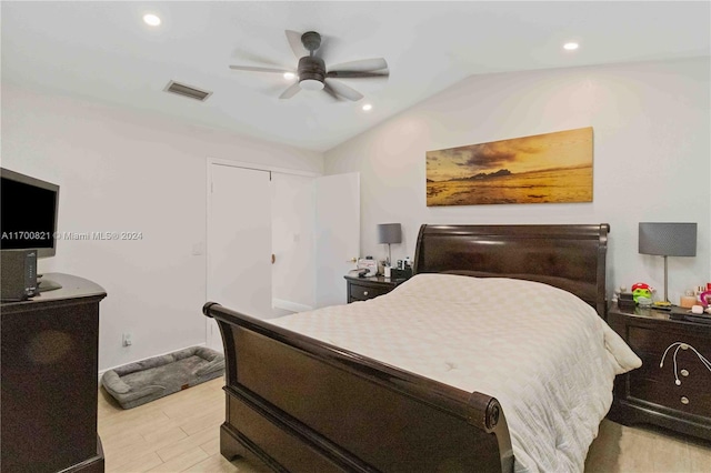 bedroom with a closet, light hardwood / wood-style floors, vaulted ceiling, and ceiling fan