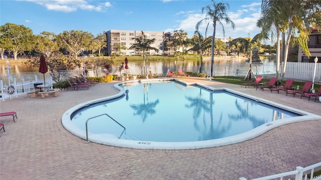 view of swimming pool with a patio and a water view