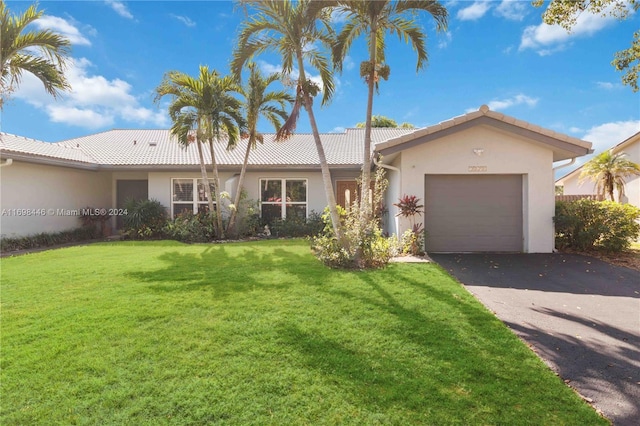 ranch-style house featuring a front lawn and a garage