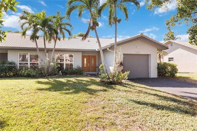 ranch-style home with a garage and a front lawn