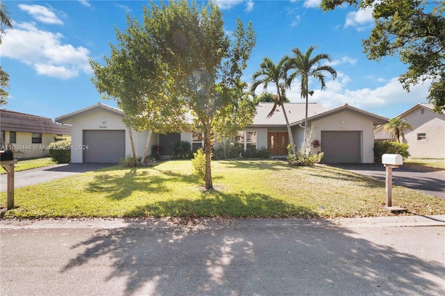 ranch-style house with a front yard and a garage