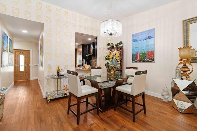 dining space with wood-type flooring and a chandelier