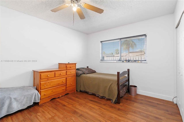 bedroom featuring ceiling fan, dark hardwood / wood-style flooring, a textured ceiling, and a closet