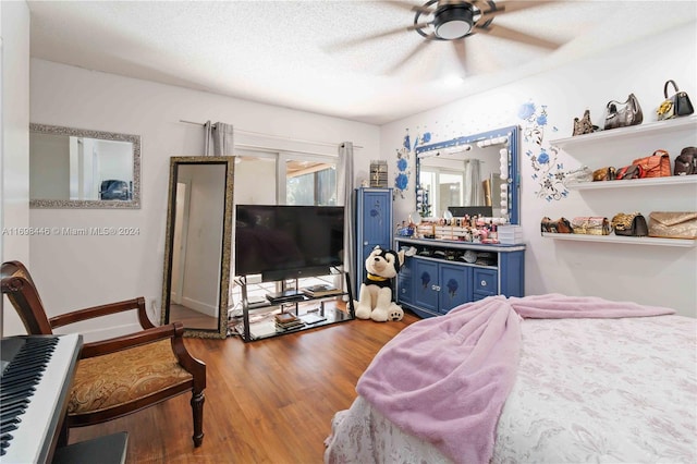 bedroom with hardwood / wood-style floors, a textured ceiling, and ceiling fan