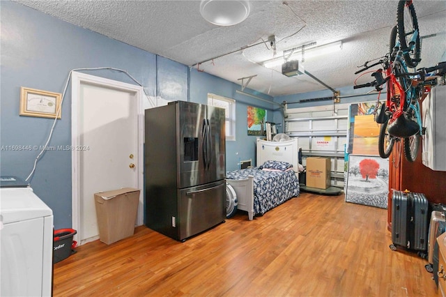 garage with a garage door opener, stainless steel fridge with ice dispenser, and washer / clothes dryer