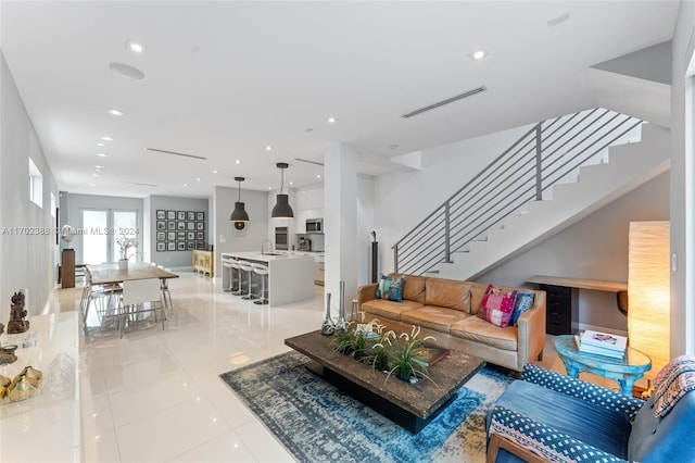 tiled living room featuring sink and french doors