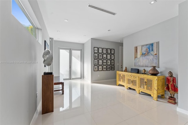 hallway with french doors and light tile patterned flooring