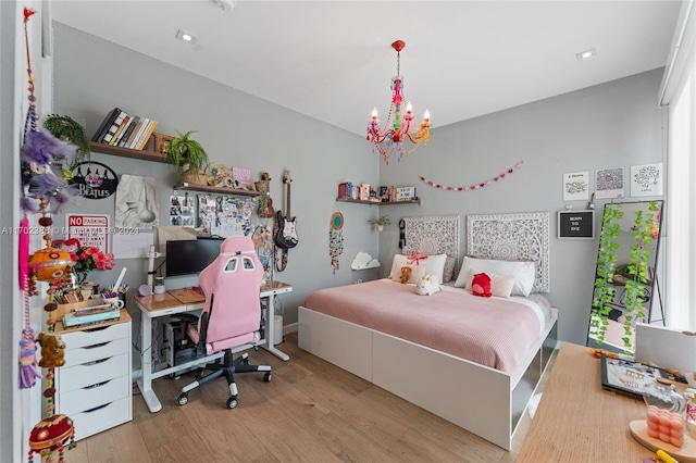 bedroom with light wood-type flooring and an inviting chandelier