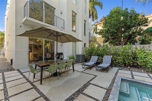 view of patio featuring a balcony and a swimming pool