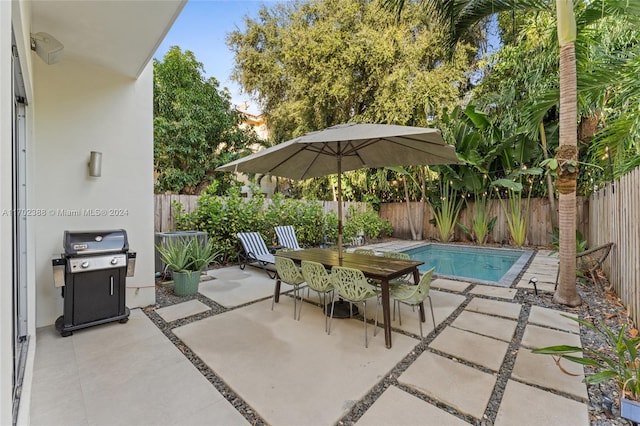 view of patio / terrace with a fenced in pool and a grill