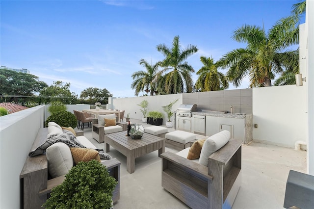 view of patio with grilling area, an outdoor living space, and exterior kitchen