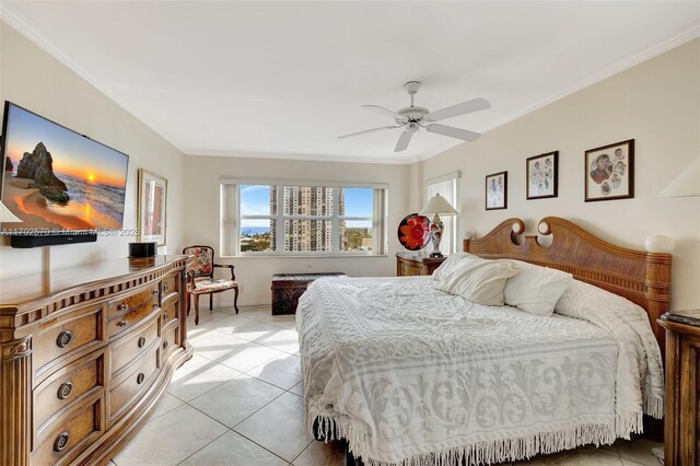 tiled dining area with crown molding, a water view, and ceiling fan