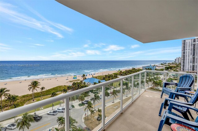 balcony with a water view and a view of the beach