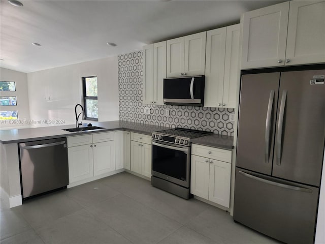 kitchen with tasteful backsplash, white cabinetry, sink, and appliances with stainless steel finishes