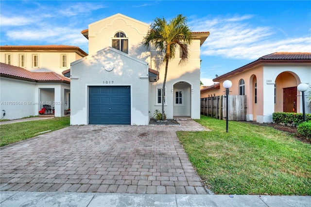 mediterranean / spanish home featuring a garage and a front yard