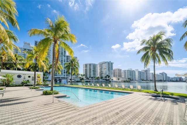 view of pool featuring a water view and a patio area