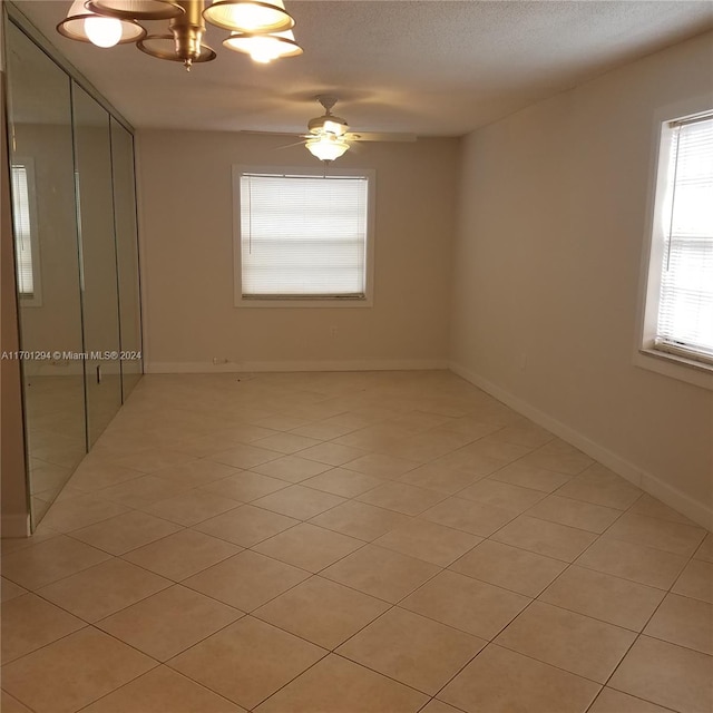 tiled spare room featuring a textured ceiling and ceiling fan