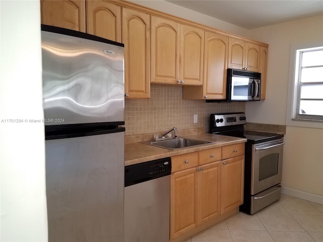 kitchen with decorative backsplash, light brown cabinetry, stainless steel appliances, sink, and light tile patterned floors