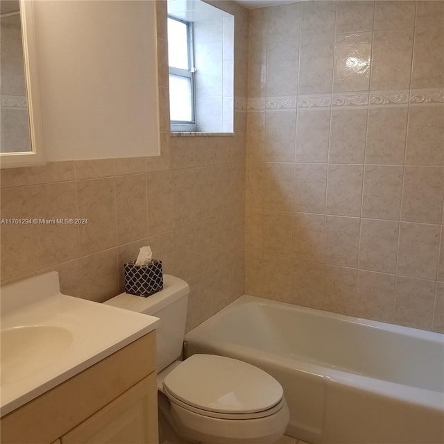 full bathroom featuring vanity, toilet, tile walls, and tiled shower / bath combo