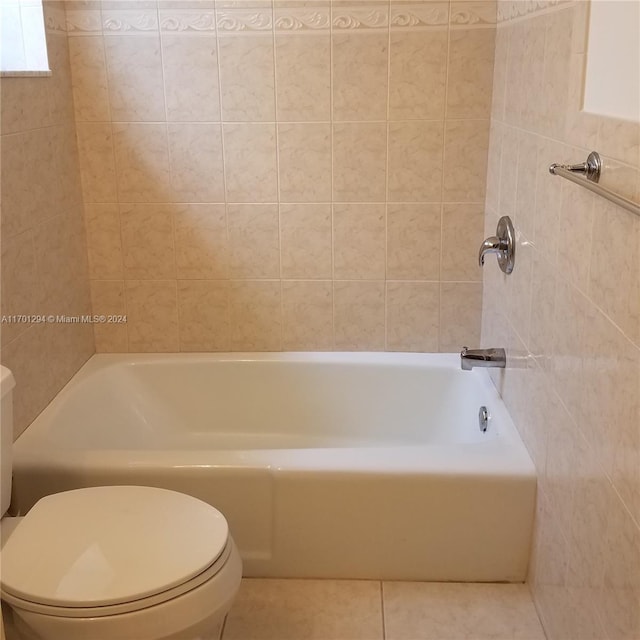 bathroom with tile patterned flooring, shower / bathtub combination, tile walls, and toilet