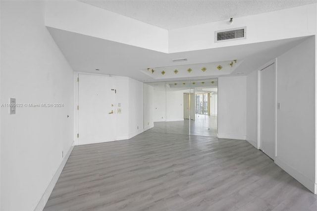 empty room featuring light wood-type flooring and a textured ceiling