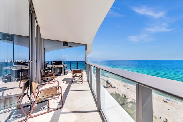 balcony featuring a view of the beach and a water view