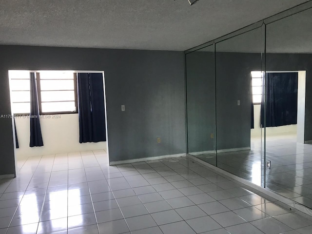 unfurnished room featuring light tile patterned floors and a textured ceiling