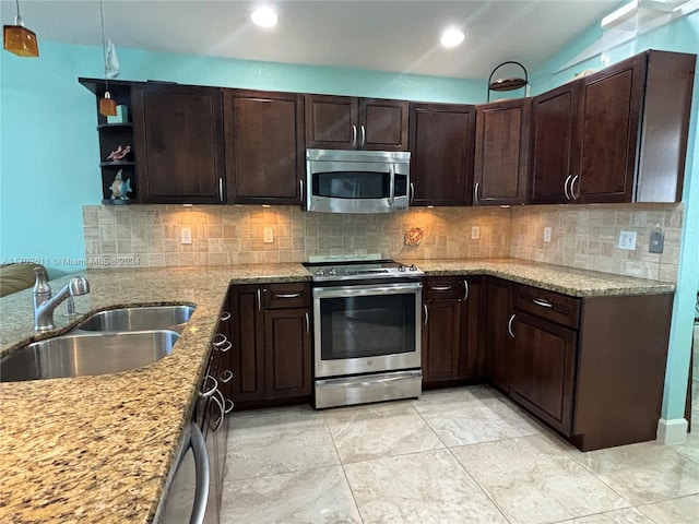 kitchen featuring light stone countertops, appliances with stainless steel finishes, decorative backsplash, and sink