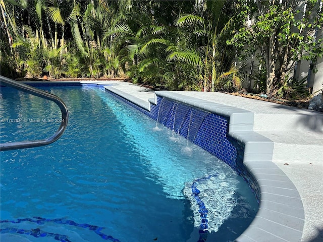 view of swimming pool with pool water feature