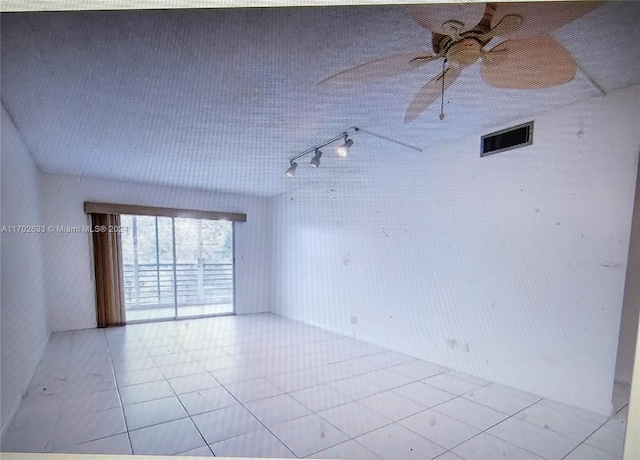 empty room featuring ceiling fan and light tile patterned floors