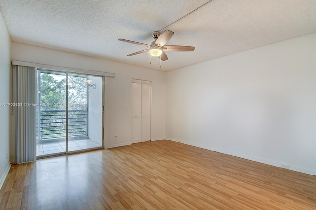 empty room featuring a textured ceiling, light hardwood / wood-style floors, and ceiling fan