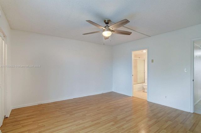 empty room with ceiling fan and light hardwood / wood-style floors