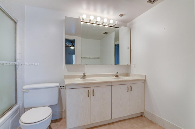 full bathroom featuring tile patterned floors, vanity, toilet, and enclosed tub / shower combo