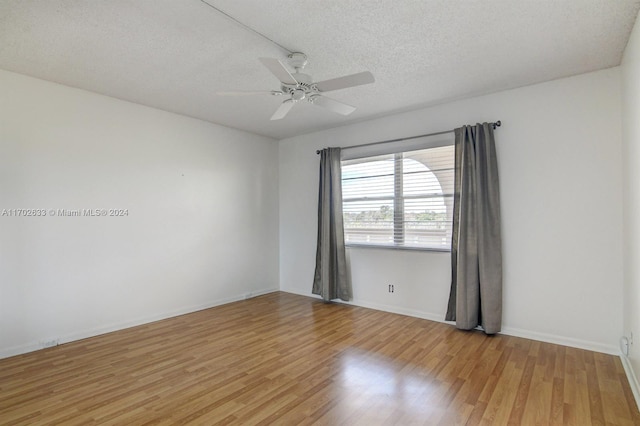 spare room featuring ceiling fan, light hardwood / wood-style floors, and a textured ceiling