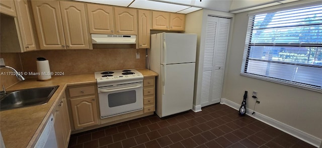 kitchen featuring white appliances, dark tile patterned flooring, sink, light brown cabinetry, and tasteful backsplash